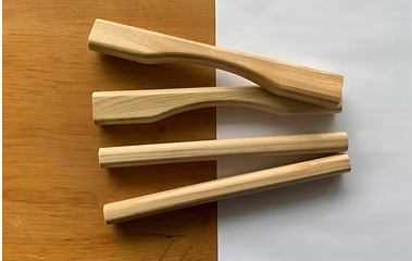 Wooden canoe gunwale pieces laid out on a workbench
