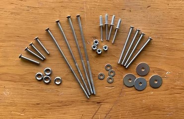 Assorted stainless screws, bolts and washers on a workbench